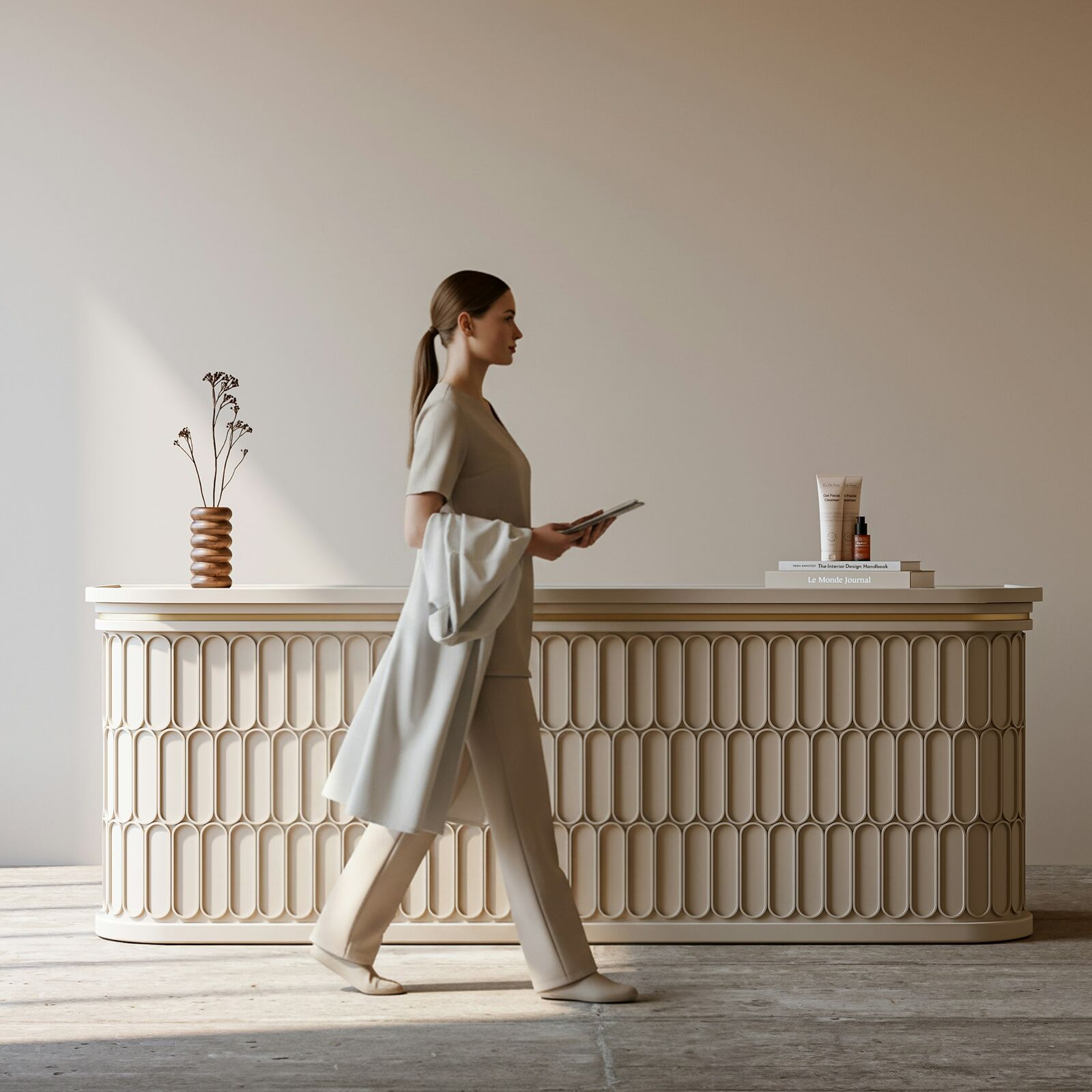 A woman walking past a sculpted cream reception desk